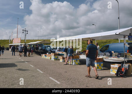 Oudeschild Texel / Niederlande - August 2019: Friday Harbor Markt in Stadt Oudeschild auf der Insel Texel mit Menschen zu Fuß durch den Verkauf von Messeständen Stockfoto