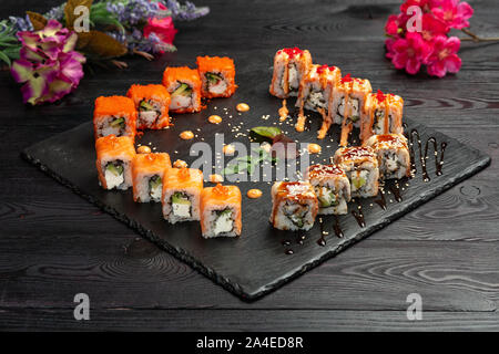 Maki Sushi Rollen auf schwarzem Stein auf dunklem Hintergrund Stockfoto