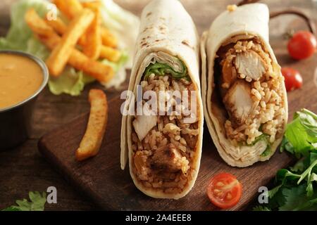 Burritos Wrap mit gegrilltem Hähnchen Reis und Gemüse auf hölzernen Hintergrund, selektiver Fokus Stockfoto