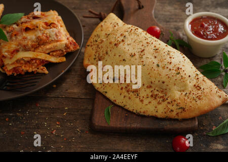 Calzone - Italienische gefaltet CheesePizza auf rustikalen hölzernen Hintergrund Stockfoto