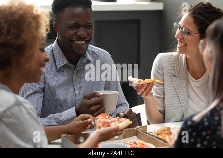 Mannschaft der multirassischen Kollegen essen Pizza genießen Mittagspause Stockfoto