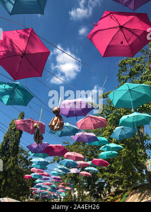 Die bunte Sonnenschirme hängen über der Straße bei Chatuchak Market, Bangkok, Thailand. Stockfoto