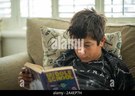 Junge liest Buch zu Hause Stockfoto