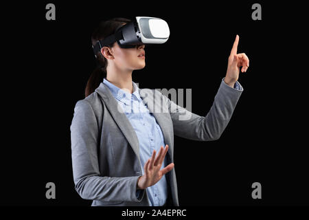 Dame in Virtual Reality Headset drücken Unsichtbare Taste, schwarzer Hintergrund Stockfoto