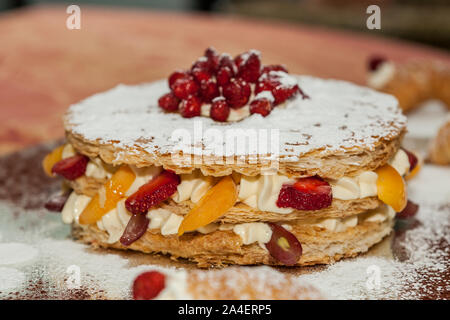 Köstliche Kuchen, Blätterteig mit frischem Obst. Pfirsich, Erdbeere, Pfirsich und Trauben. Stockfoto