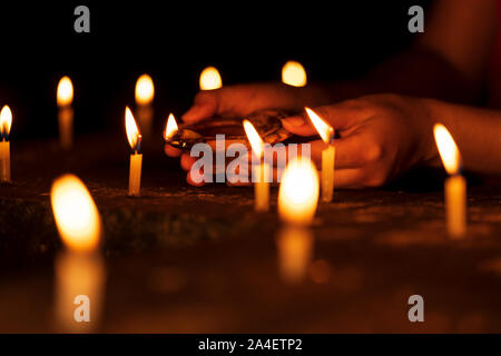 Frau Hände halten ein Diya, Beleuchtung Kerzen in der diwali feiern Nacht im Tempel. Hintergrund Konzept für indisch-hinduistischen Ritualen, Gottesdienst, Glaube, Stockfoto