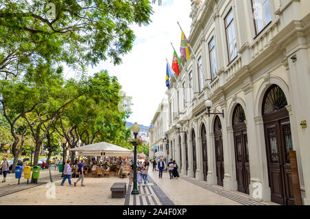 Funchal, Madeira, Portugal - Sep 10, 2019: Gebäude des Theaters in Madeiras Hauptstadt - Teatro Municipal Baltazar Dias. Die Menschen auf der Straße im historischen Zentrum. Touristische Attraktionen. Wehenden Fahnen. Stockfoto