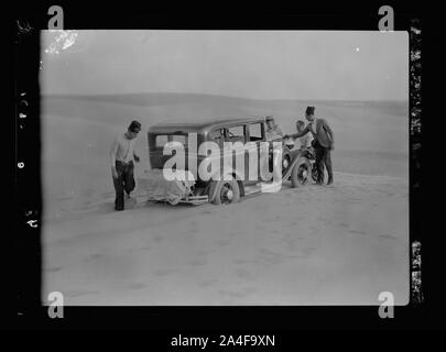 Auf den Sinai mit dem Auto. Auto stecken mitten in einer Sanddüne. Sandverwehungen auf der anderen Straßenseite Stockfoto