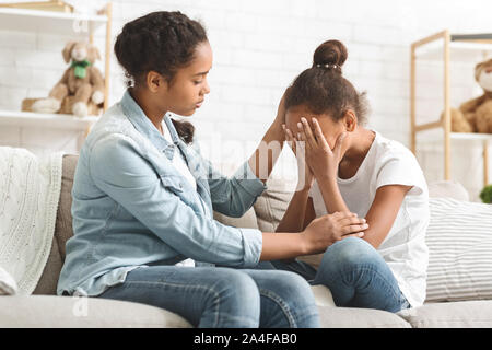 Weinende Mädchen von ihrer älteren Schwester getröstet werden Stockfoto