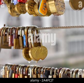 Foto von Schlössern mit Regen fällt auf eine Brücke für die Menschen in der Liebe, in Ljubljana, Slowenien, Europa. Mit unscharfen Fluss Ljubljanica und berühmten Marktplatz Stockfoto
