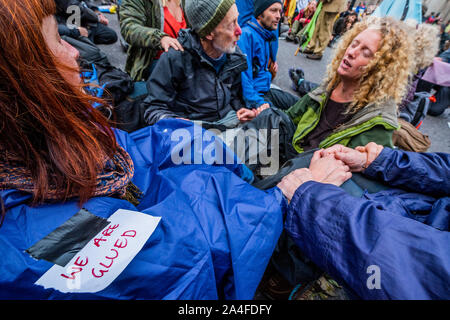 London, Großbritannien. 14 Okt, 2019. Gemeinsam seit 11 Uhr morgens - Demonstranten in die Mitte verschieben durch die Blockade der Kreuzung bei der Bank - Der sechste Tag der Ausrottung Rebellion Oktober Aktion die Straßen in Central London blockiert hat geklebt. Sie sind einmal hervorheben, das Klima, mit der Zeit den Planeten vor einer Klimakatastrophe zu speichern. Dies ist Teil der laufenden ER und andere Proteste zu handeln, die von der britischen Regierung auf die "klimakrise" verlangen. Die Aktion ist Teil einer international koordinierten protestieren. Credit: Guy Bell/Alamy leben Nachrichten Stockfoto