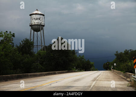 Strawn, TX, USA, der Strawn Wasserturm neben einer texanischen Autobahn gegen stürmischen grauen Himmel mit Kopierraum, Texas, Amerika Stockfoto