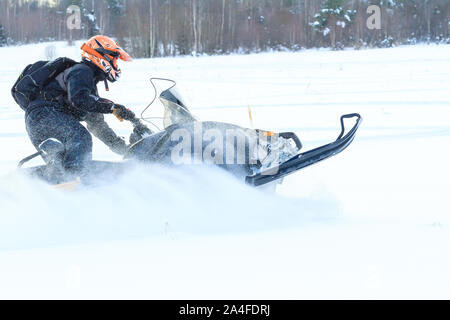 Teriberka, Russland - 24. Februar 2018: Mann in einem Sport Helm reitet ein Schneemobil Stockfoto