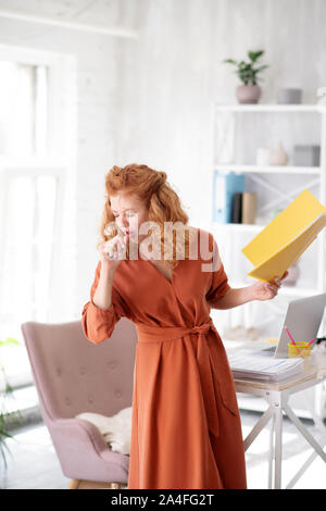 Frau von zu Hause aus zu arbeiten, während das Leiden von Husten Stockfoto
