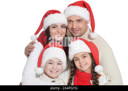 Familie mit Kindern in Santa Hüte auf weißem Hintergrund posiert Stockfoto