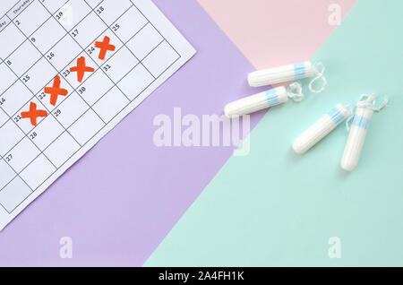 Flach Komposition mit Kalender und Menstruation Tampons auf Blau Rosa und Lila pastell Hintergrund. Gynäkologie Konzept. Kritischen Tagen pms Zeitraum Reihen Stockfoto