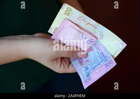 Weibliche Hände zählt grosse Menge der ukrainischen Geld während der vergütungszeitraum in der Ukraine. Reiches leben Konzept Stockfoto