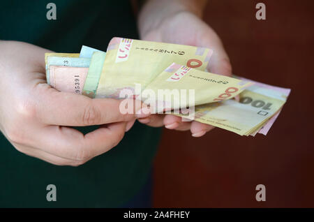 Weibliche Hände zählt grosse Menge der ukrainischen Geld während der vergütungszeitraum in der Ukraine. Reiches leben Konzept Stockfoto