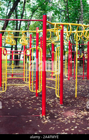 Spielplatz im Freien geräte Metall Kinder bars Swing gelbe und rote Farbe auf die natürlichen Hintergrund anzeigen. Stockfoto