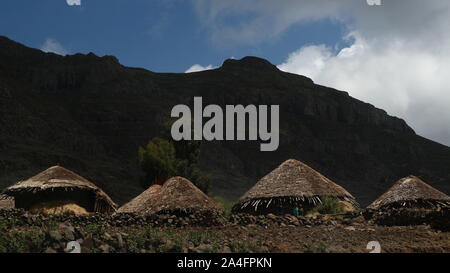 Westlichen äthiopischen Hochland/Äthiopien - 20. April 2019: traditionellen strohgedeckten afrikanischen Hütten neben landwirtschaftlichen Feldern Stockfoto