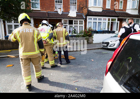 Feuerwehrmänner stehen über Glasscherben und eine Tür, die in der Straße von einem großen gasexplosion auf Foxley Gärten, ein Wohn-s geblasen wurden. Stockfoto