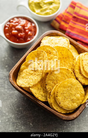 Runde Nacho Chips. Gelbe Tortilla Chips in der Schüssel auf alten Küchentisch. Stockfoto