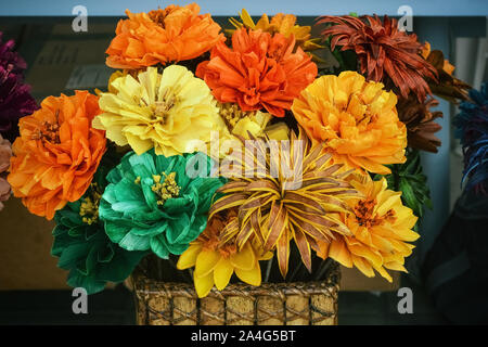 Blumenstrauß aus leuchtend gelben, roten und grünen Blumen in einem Weidenkorb. Stockfoto