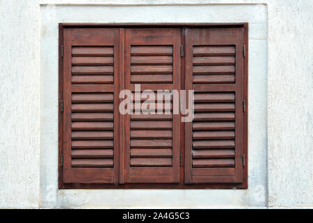 Fenster mit braunen Fensterläden aus Holz. Aus einer Reihe von Windows der Welt. Stockfoto