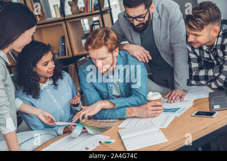 Startupers zusammen arbeiten im Büro sitzen, diskutieren lebhaft beste Farbe aus der Palette Stockfoto