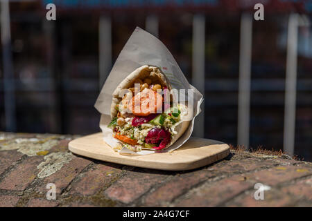 Schöne falafel Pita auf einer hölzernen Platte draußen auf einer Mauer Stockfoto