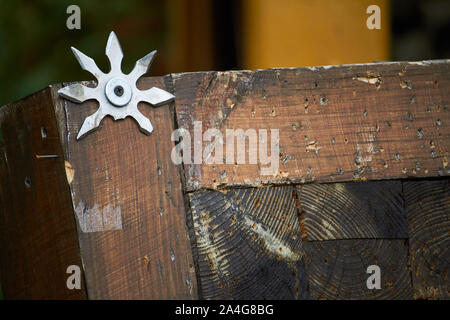 In der Nähe von Werfen Board für das Werfen Stern dekoriert mit gebrochenen Shurikens, selektiver Fokus Stockfoto