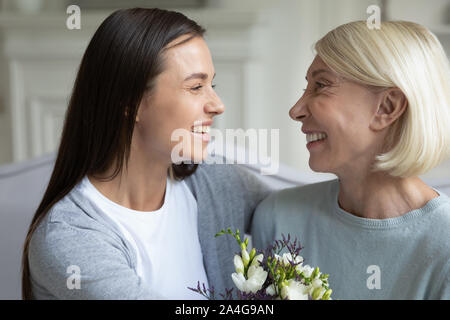 Tausendjährige erwachsen Tochter gratulieren mittleren Alter Mutter mit dem Geburtstag. Stockfoto