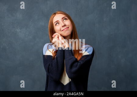 Junge Mädchen in warmen Blau Pullover an der Wand isoliert. Stockfoto