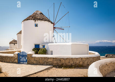 Mykonos, Griechenland. Malerischer Blick auf berühmte weiß getünchten Windmühlen in der Stadt an der Küste an einem schönen Sommer Tag. Stockfoto