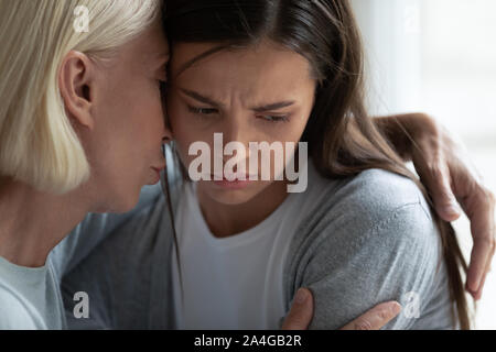 Empathische Frau mittleren Alters umarmen umgekippt Tochter. Stockfoto