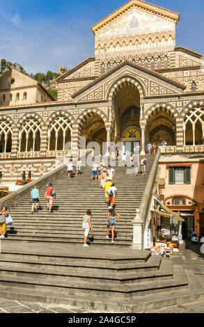 AMALFI, ITALIEN - AUGUST 2019: Menschen klettern die Schritte der Kathedrale des Heiligen Apostels Andreas im Zentrum von Amalfi Stockfoto