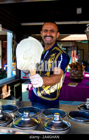 Straße Eis Anbieter im traditionellen osmanischen Kleidung mit Milch Dichtmasse Eis türkischen Ziege Creme in Fethiye, Türkische Riviera, Türkei Stockfoto