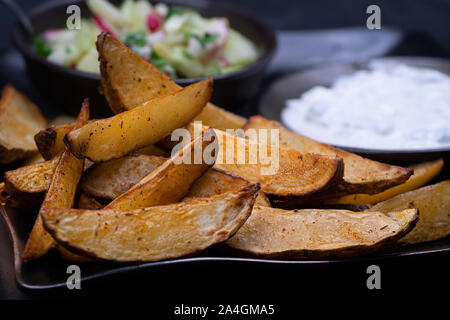 Air Fritteuse geröstete Kartoffeln mit Gewürzen, serviert mit Salat und Joghurt Dip Stockfoto