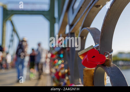 Nahaufnahme von roten Herzen Master Keys Vorhängeschlösser auf Kurve eiserne Geländer auf fußgängerbrücke Iron Bridge, Eiserner Steg, überqueren Sie den Fluss. Stockfoto