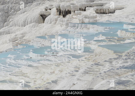 Pamukkale in der Türkei ist bekannt für seine mineral-reiche Thermalwasser nach unten fließenden weißen Travertin Terrassen. Pamukkale ist unter dem Spitznamen Baumwolle schloss. Stockfoto