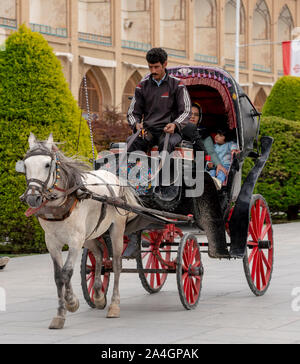 Kashan, Iran - 2019-04-14 - Naqshe Cehan Square Familie nimmt Fahrt in der Kutsche um den Platz herum. Stockfoto