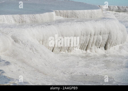Pamukkale in der Türkei ist bekannt für seine mineral-reiche Thermalwasser nach unten fließenden weißen Travertin Terrassen. Pamukkale ist unter dem Spitznamen Baumwolle schloss. Stockfoto
