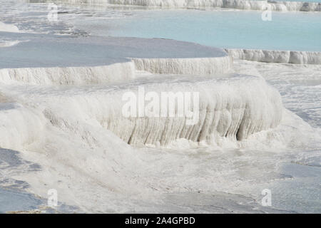 Pamukkale in der Türkei ist bekannt für seine mineral-reiche Thermalwasser nach unten fließenden weißen Travertin Terrassen. Pamukkale ist unter dem Spitznamen Baumwolle schloss. Stockfoto