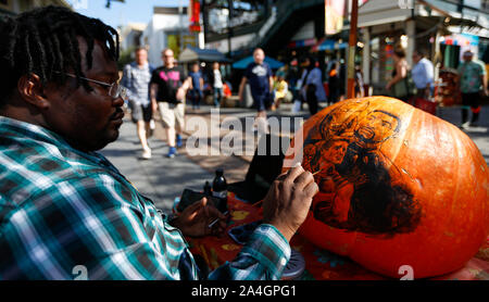 Los Angeles, USA. 13 Okt, 2019. Ein Künstler schmückt ein Kürbis während der 85 Herbstfest am ursprünglichen Bauernmarkt in Los Angeles, USA, am Okt. 13, 2019. Das jährliche Herbstfest hier am Okt. 12 gehalten wird, und 13 die Herbsternte mit verschiedenen Familie feiern Aktivitäten. Credit: Li Ying/Xinhua/Alamy leben Nachrichten Stockfoto