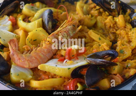 Extreme Nahaufnahme der Paella. Riesige Garnelen auf Risotto. Muscheln, Muscheln, Tintenfisch, Fisch, Krebse tragen zur authentischen spanischen Geschmack. Stockfoto