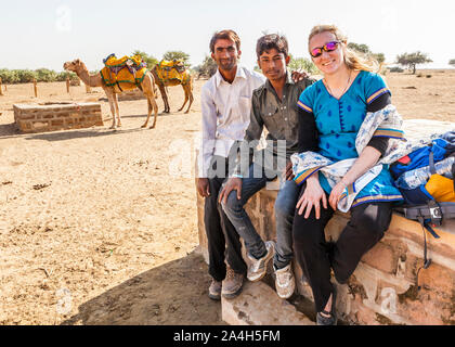 Ein tourist für ein Foto mit ihren zwei Kamel Fahrer/Führer auf einem Kamel trek Tour posieren. Kanoi, Rajasthan, Indien. Stockfoto