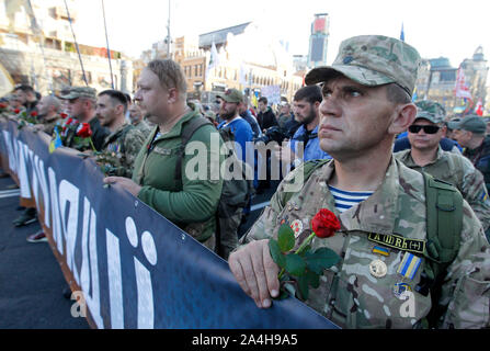 Kiew, Ukraine. 14 Okt, 2019. Ukrainische Veteran hält eine Blume im März zum Gedenken an den 77. Jahrestag der Gründung der UPA. der Ukrainischen aufständischen Armee (UPA) aktiv für die Ukrainische Unabhängigkeit von 1942 bis 1949 kämpften, vor allem in der Westukraine gegen den deutschen Nationalsozialismus und des sowjetischen Regimes. Die ukrainer auch die Verteidiger der Ukraine Tag am selben Datum. Credit: SOPA Images Limited/Alamy leben Nachrichten Stockfoto