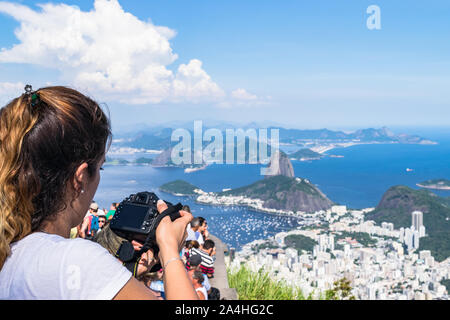 Eine Frau mit einer Kamera von Bild der Landschaft vom Berg Corcovado in Brasilien Stockfoto