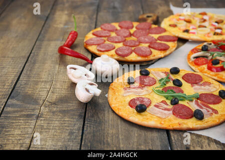 Verschiedene Pizzen auf alten Holz- Hintergrund. Stockfoto