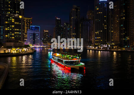 Dubai, VAE - Dezember 2, 2018: ein Vergnügen Touristenboot geht in die abendliche Besichtigungstour in der Dubai Marina. Stockfoto